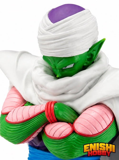 Close-up detail shot of the Piccolo figure showing the intricately sculpted face, white turban, and crossed arms with green forearms and pink elbow pads.
